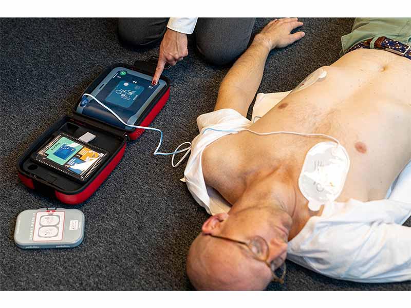 Philips frx hjärtstartare i användning. Man ligger på golvet med elektroder på sig