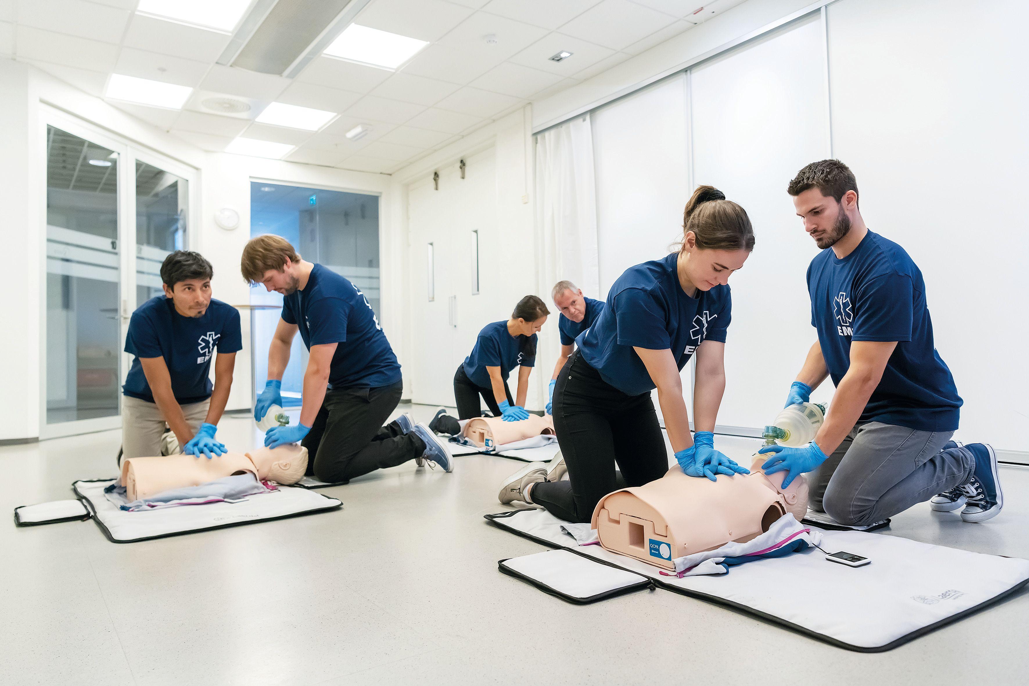 Personer sitter två och två vid HLR-dockor, de gör hjärt- och lungräddning med tvålivräddarteknik