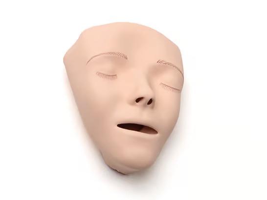 Löstagbart ansikte till HLR-docka. Ansiktet har ljus hud och är dekorerat med ögonfransar och ögonbryn.